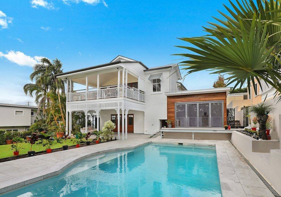 A contemporary home and swimming pool surrounded by greenery